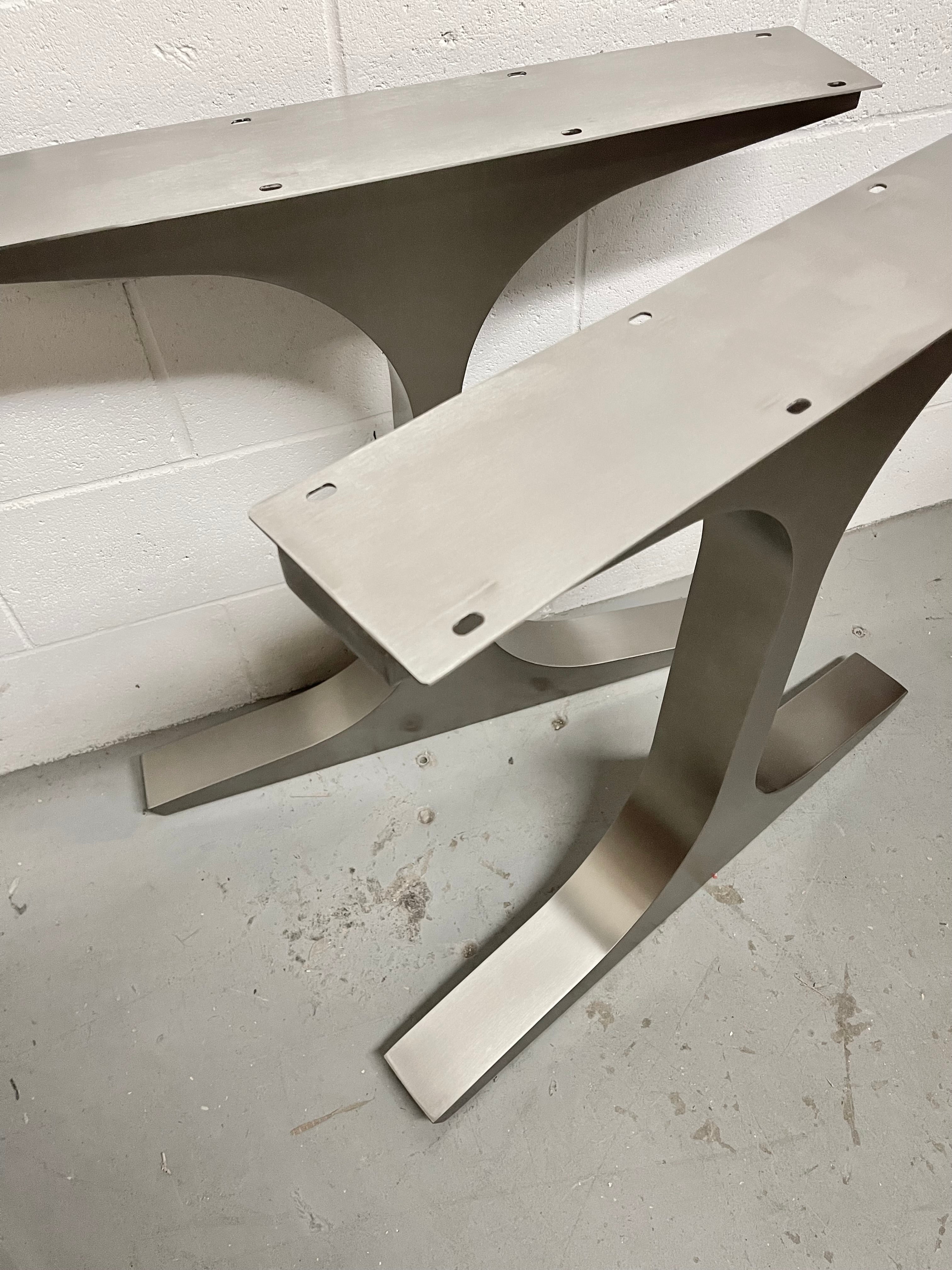 Metal brackets on a concrete floor with a white wall background