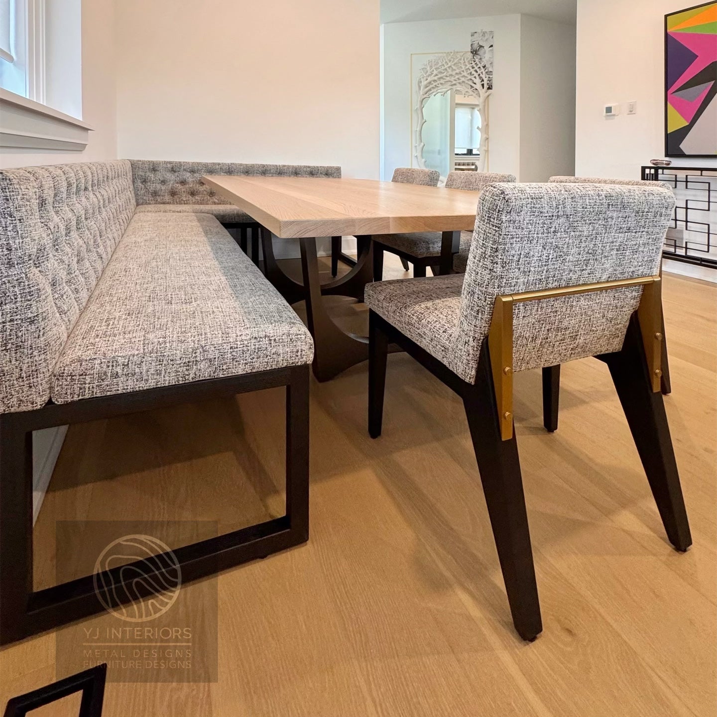Dining area with a wooden table, chairs, and a bench in a modern interior setting.