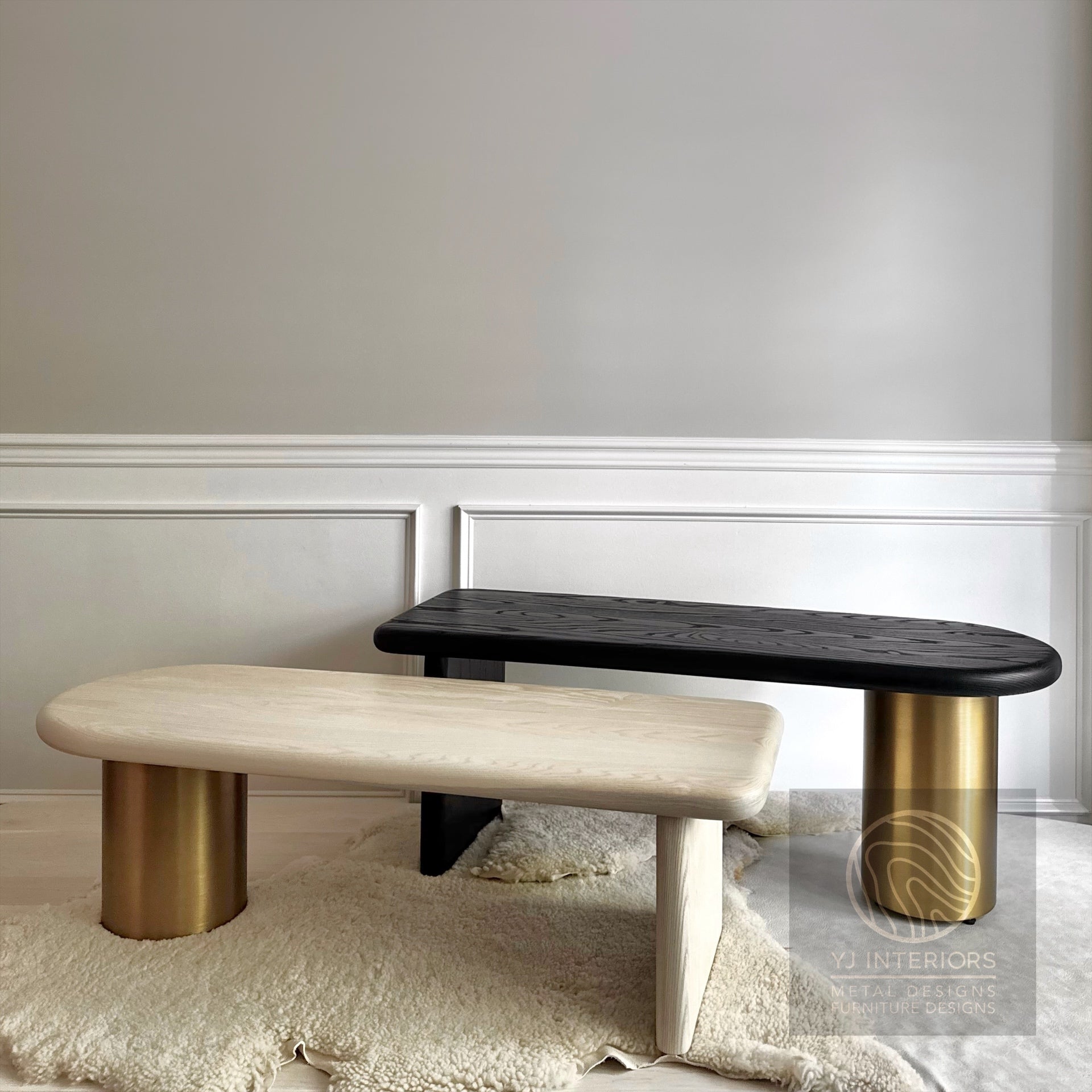 Two modern benches with gold legs on a light gray floor against a white wall.