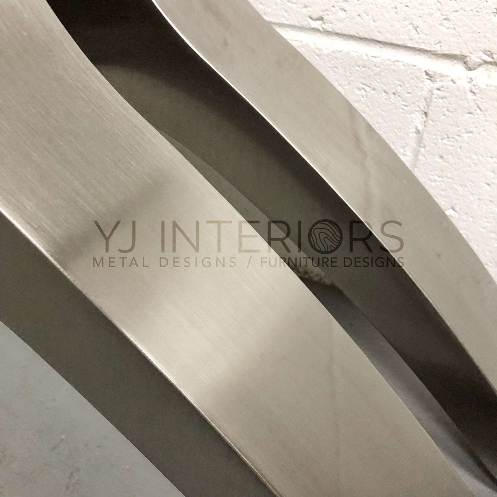 Metallic architectural detail with 'YJ Interiors' branding
